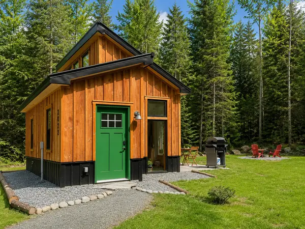 Cabin entry with stone pathway and grill in summer