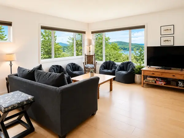 Open living and dining room with floor-to-ceiling windows framing the lake