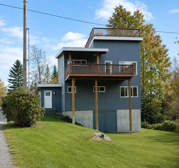 Side view of the modern three-story blue cedar home