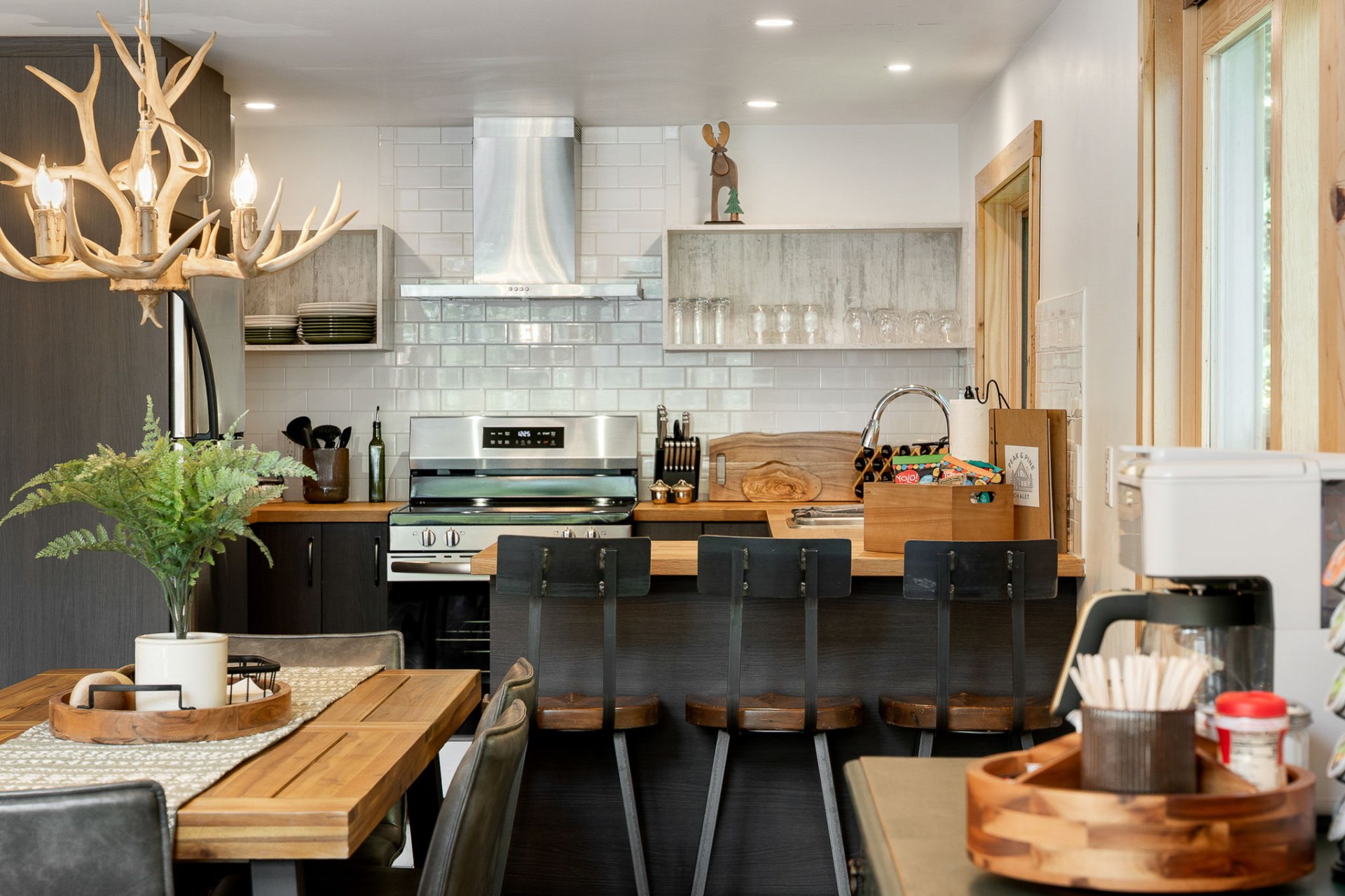 Modern cabin kitchen with antler chandelier and dining bar
