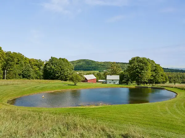 Private pond with rolling hills and the farmhouse beyond