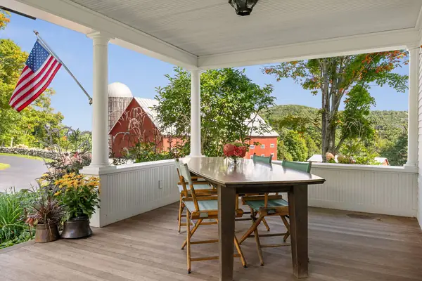 Covered porch dining table looking out to the red barn