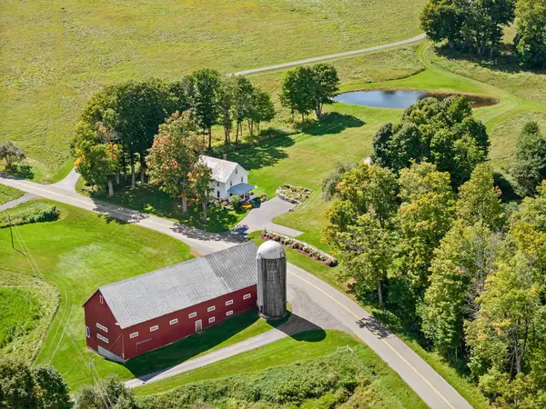 Aerial view of the farmhouse, red barn, and pond