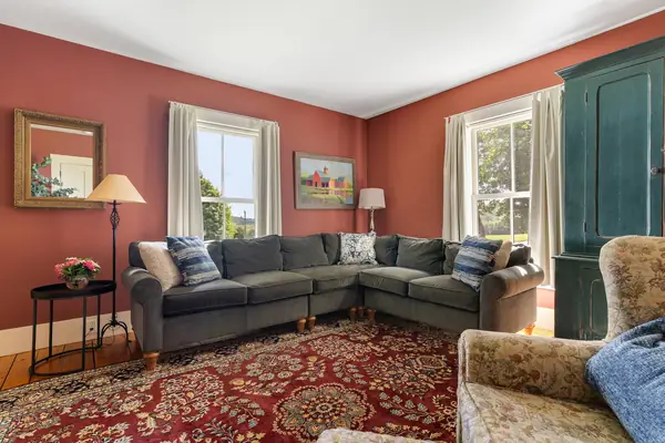 Main living room with large sectional and warm red walls