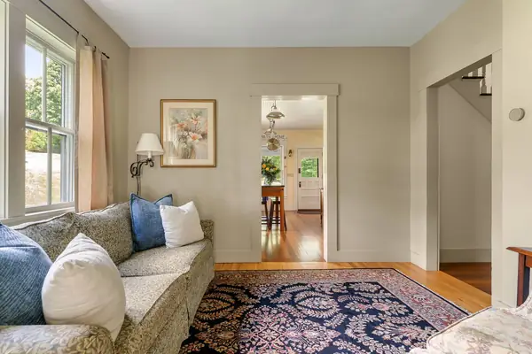 Separate sitting room with sofa and garden views