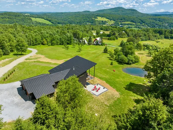 Aerial view of the home, pond, and 100 private acres